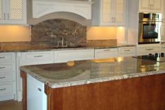 Crema Bordeaux granite countertops and island with full height splash behind sink.