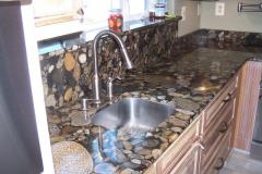 Gold Marinace countertop with full height splash behind sink