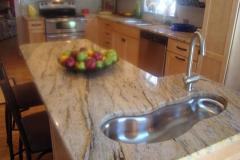 Granite kitchen and island with unique second sink and seating.