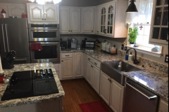 Granite kitchen countertops with cooktop in island and farm sink in Prince Frederick, MD