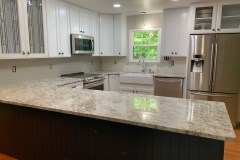 African Rainbow Granite countertops with a porcelain apron front farm sink in Prince Frederick, MD