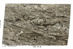 Blue Dunes granite 1643.  Heavy in movement with rich browns and golds and accents of blue. Would go well with a white, gray or neutral color scheme.  Mid price range.
