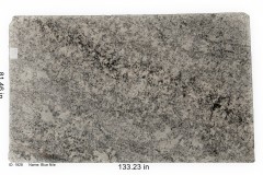 Blue Nile granite. A shade of white covered in gold, navy blue, and black specks. Has slight movement and full of mica which adds a touch of sparkle.  Goes well with any color scheme.  Low price range.