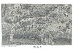 Monte Cristo granite.  Cream colored bedrock with runs of blue and tan, heavy with quartz deposits.  This stone looks like it was cut out of the side of a mountain.  Low-mid price range.