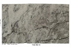 Thunder White granite.  A gray stone with a purple-ish color due to the massive amount of garnet and dark gray veining.  Comparable to what a storm cloud looks like.   Low price range.